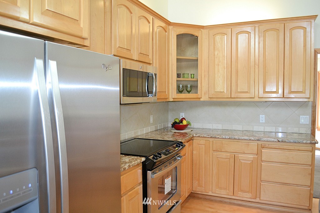 2469 Goss Ridge Road Freeland, WA 98249 - Photo 9 of 25 a kitchen with stainless steel appliances granite countertop a refrigerator a stove and a sink with cabinets