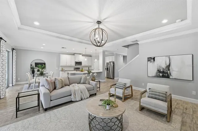 a living room with furniture chandelier and a clock