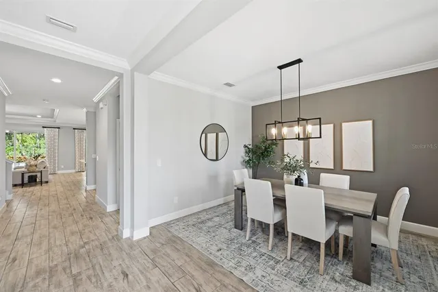 a dining room with furniture a chandelier and wooden floor