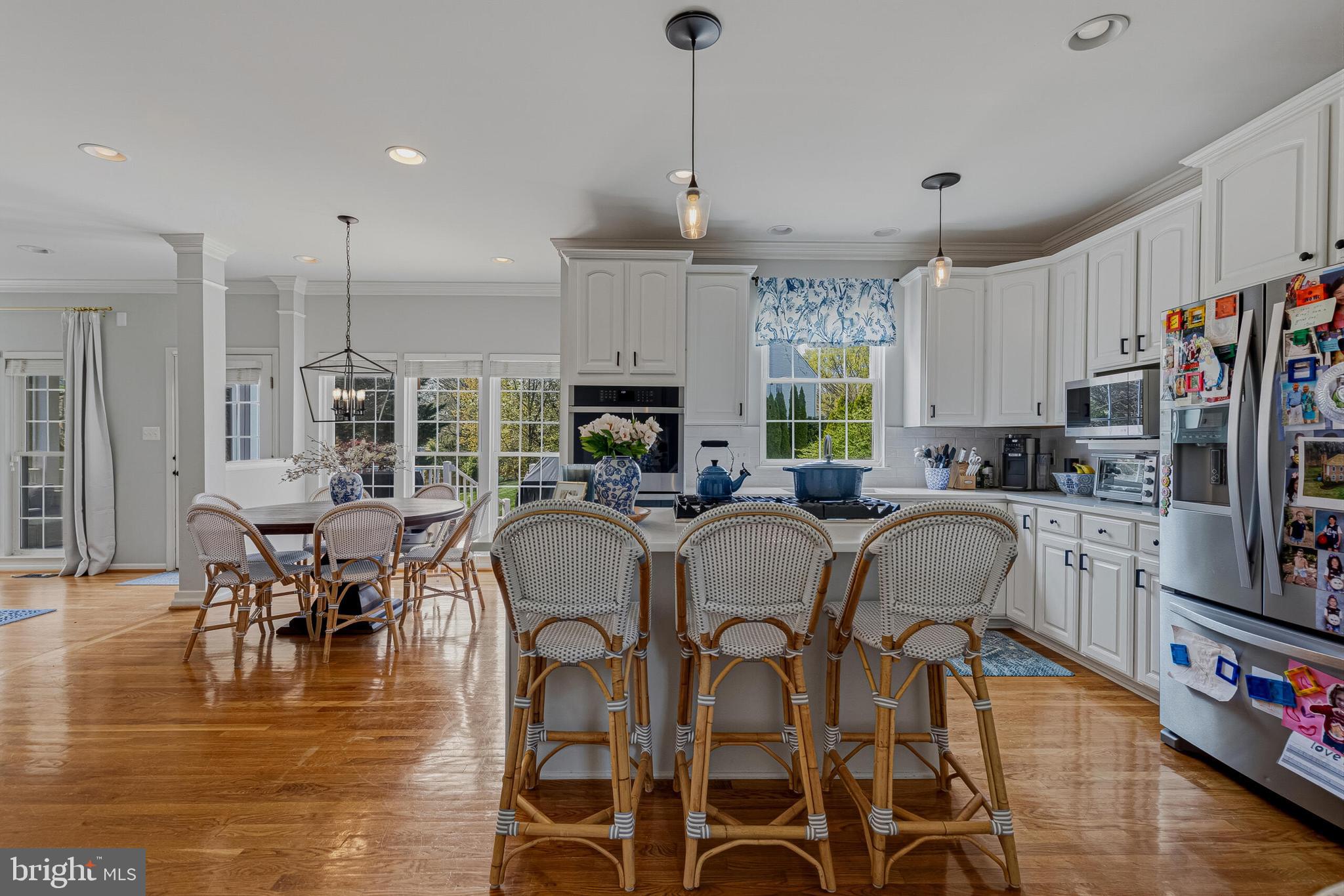 1403 Harle Place Southwest Leesburg, VA 20175 - Photo 3 of 41 a kitchen with stainless steel appliances granite countertop a stove top oven a sink a dining table and chairs with wooden floor