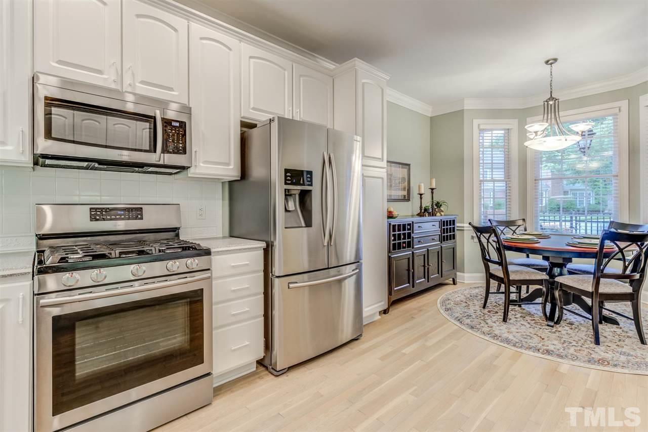 3606 Burwell Rollins Circle Raleigh, NC 27612 - Photo 14 of 30 a kitchen with stainless steel appliances a stove a refrigerator microwave and cabinets