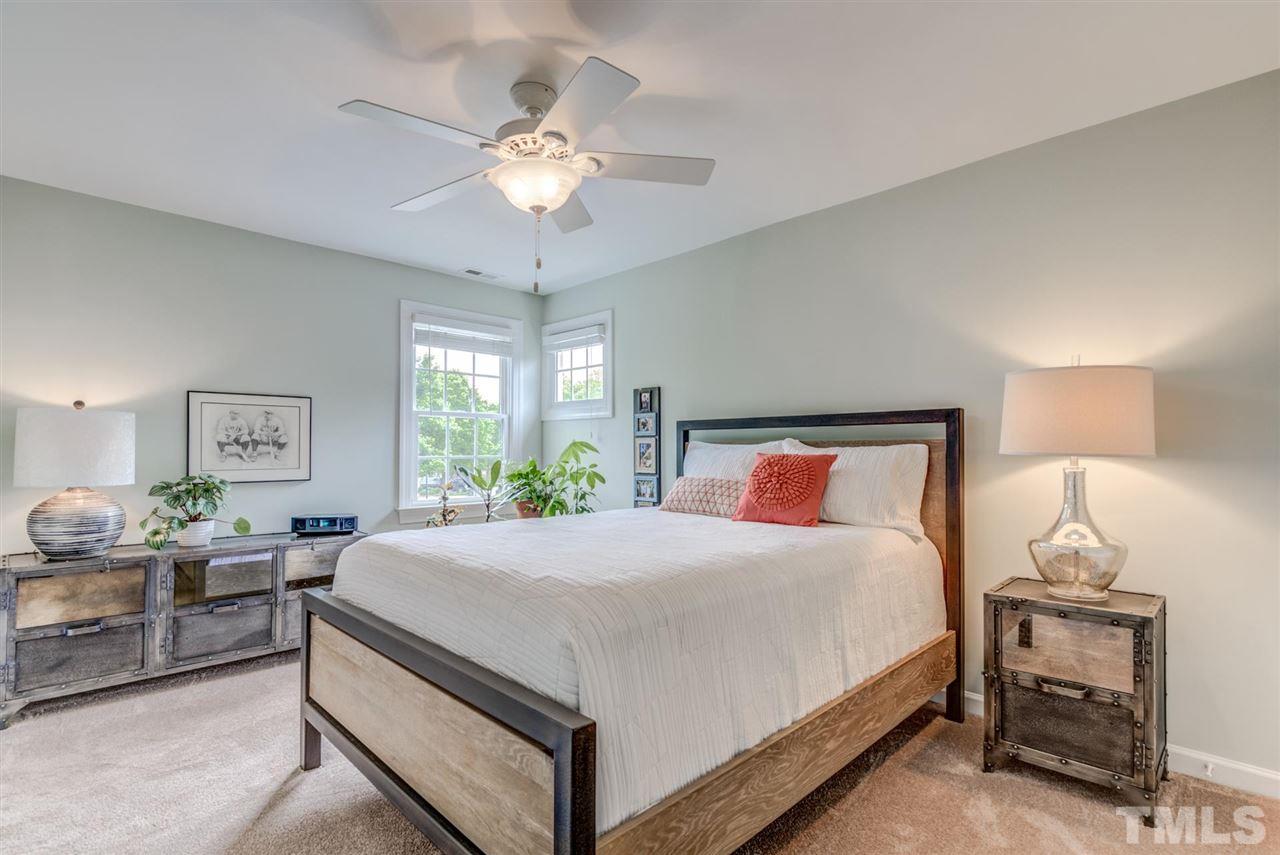 3606 Burwell Rollins Circle Raleigh, NC 27612 - Photo 23 of 30 a bedroom with a large bed and a chandelier