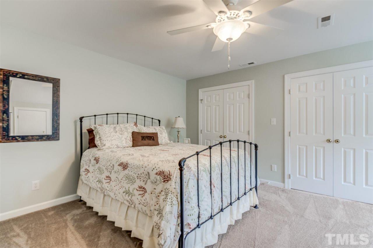 3606 Burwell Rollins Circle Raleigh, NC 27612 - Photo 25 of 30 a bedroom with a bed and a chandelier