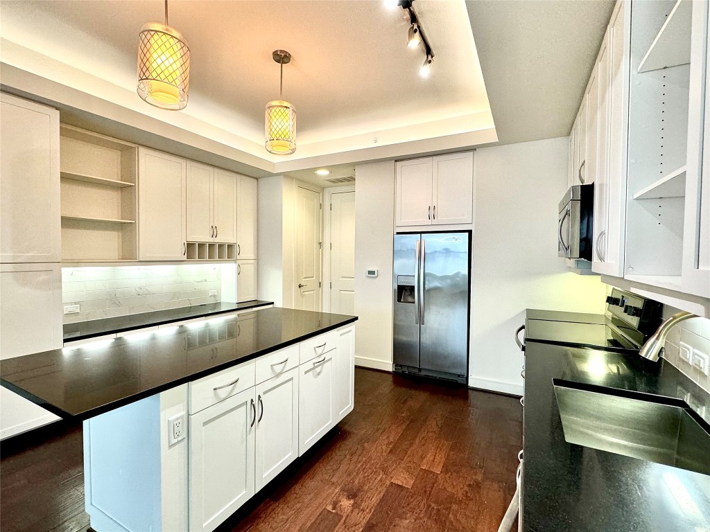 2303 Mid Lane, Unit 318 Houston, TX 77027 - Photo 11 of 25 a kitchen with stainless steel appliances granite countertop a sink a refrigerator and a stove