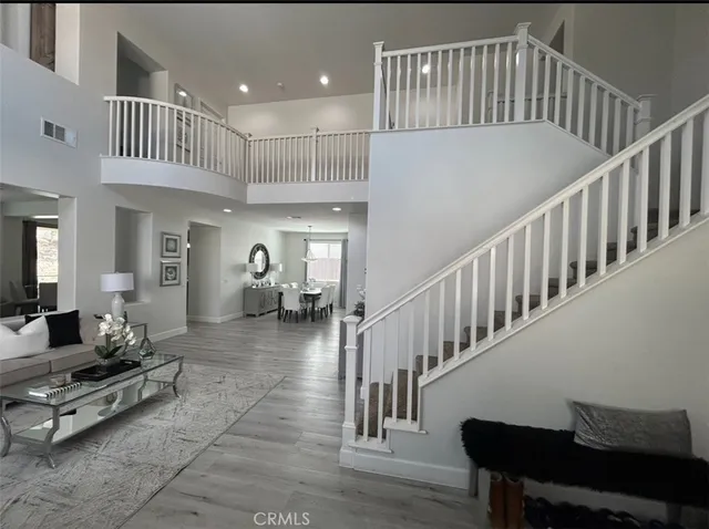 a living room with dining room furniture and a wooden floor