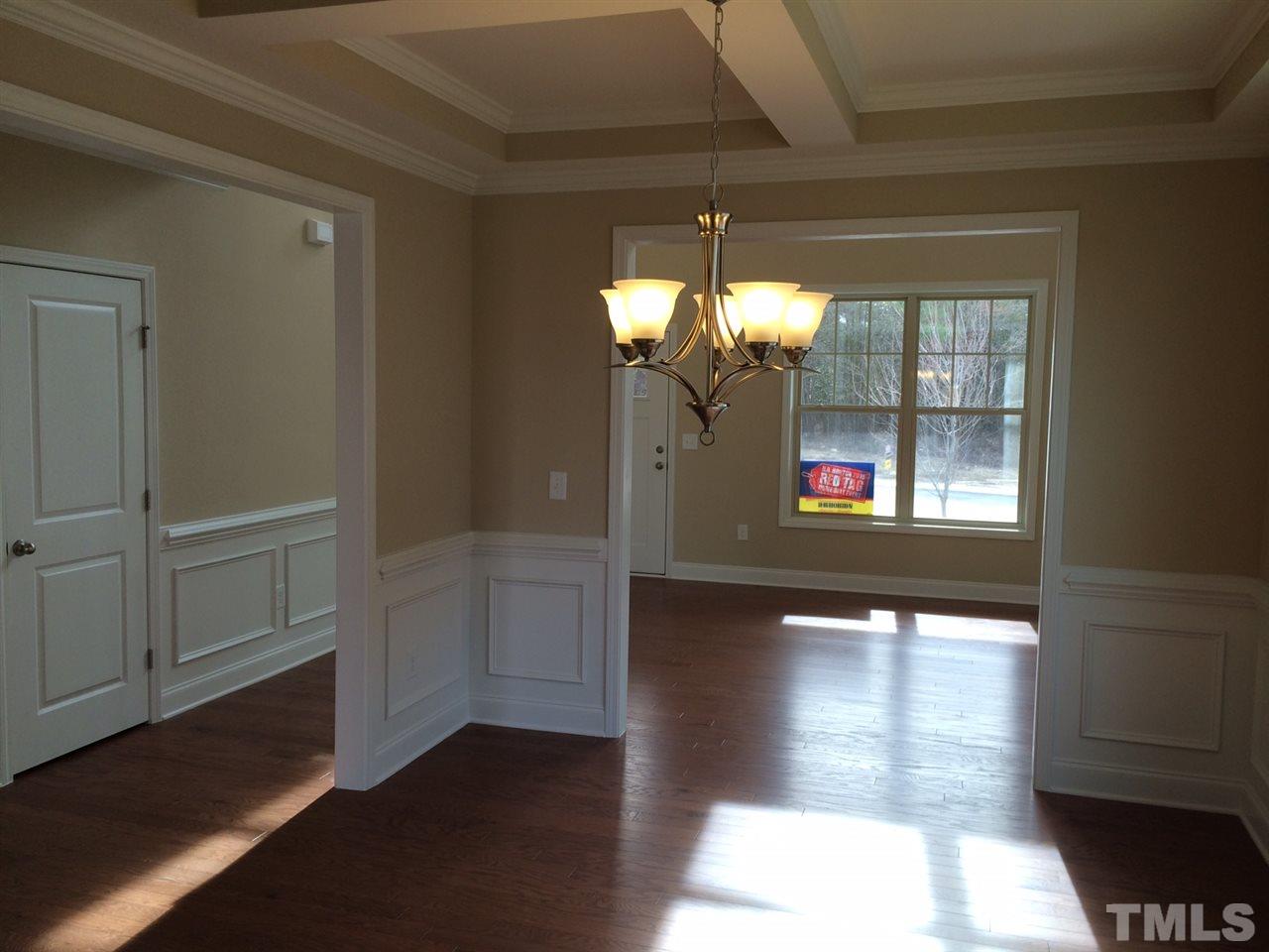 7464 Randshire Way Raleigh, NC 27616 - Photo 11 of 25 a view of a hallway with wooden floor and a dining room