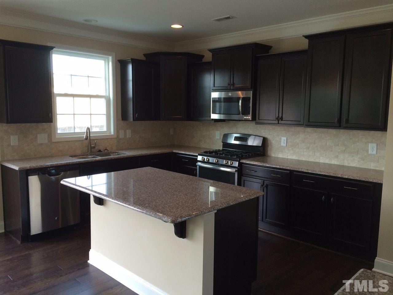 7464 Randshire Way Raleigh, NC 27616 - Photo 5 of 25 a kitchen with a sink a stove a microwave and cabinets