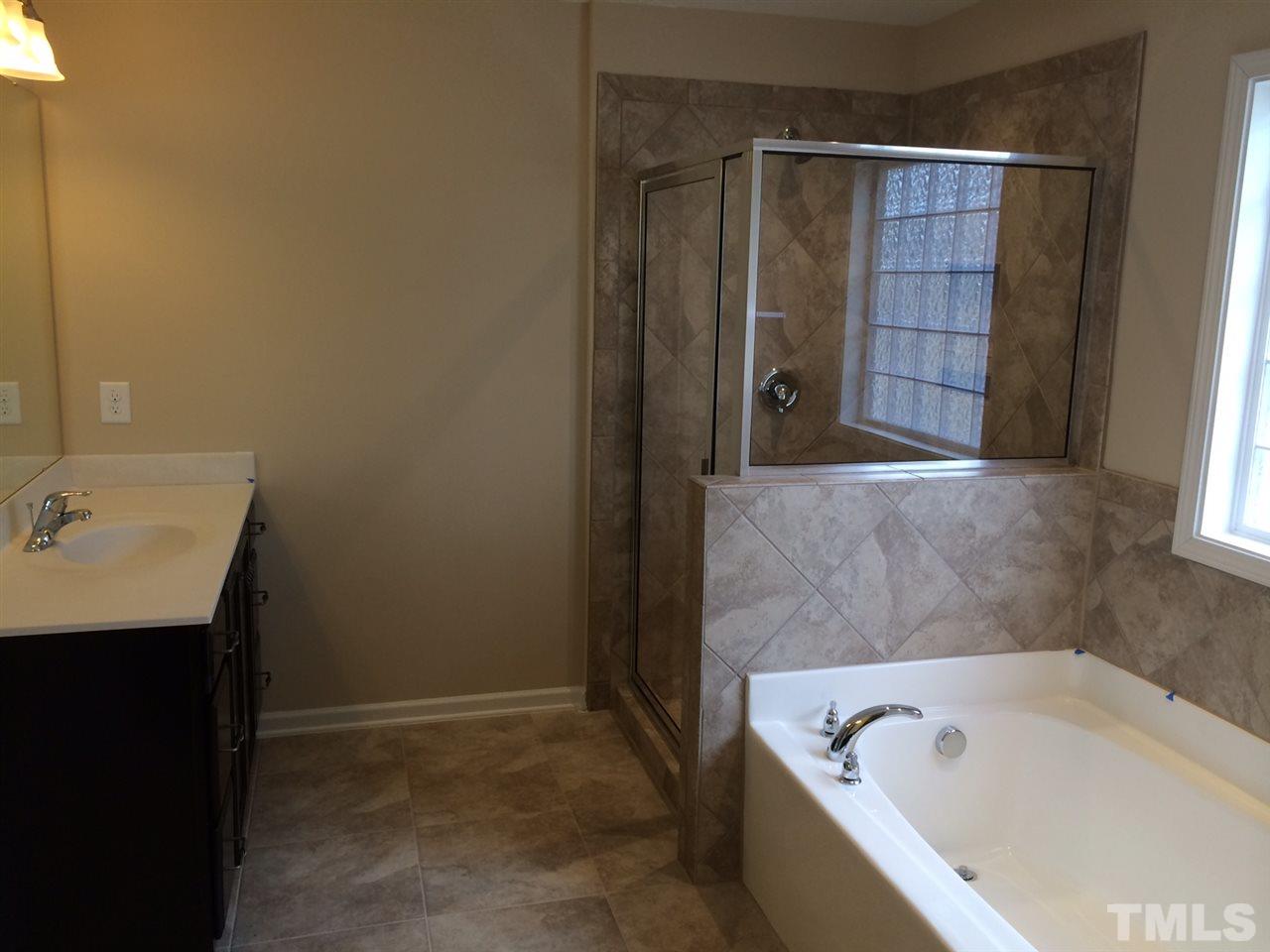 7464 Randshire Way Raleigh, NC 27616 - Photo 7 of 25 a bathroom with a tub a sink and a shower
