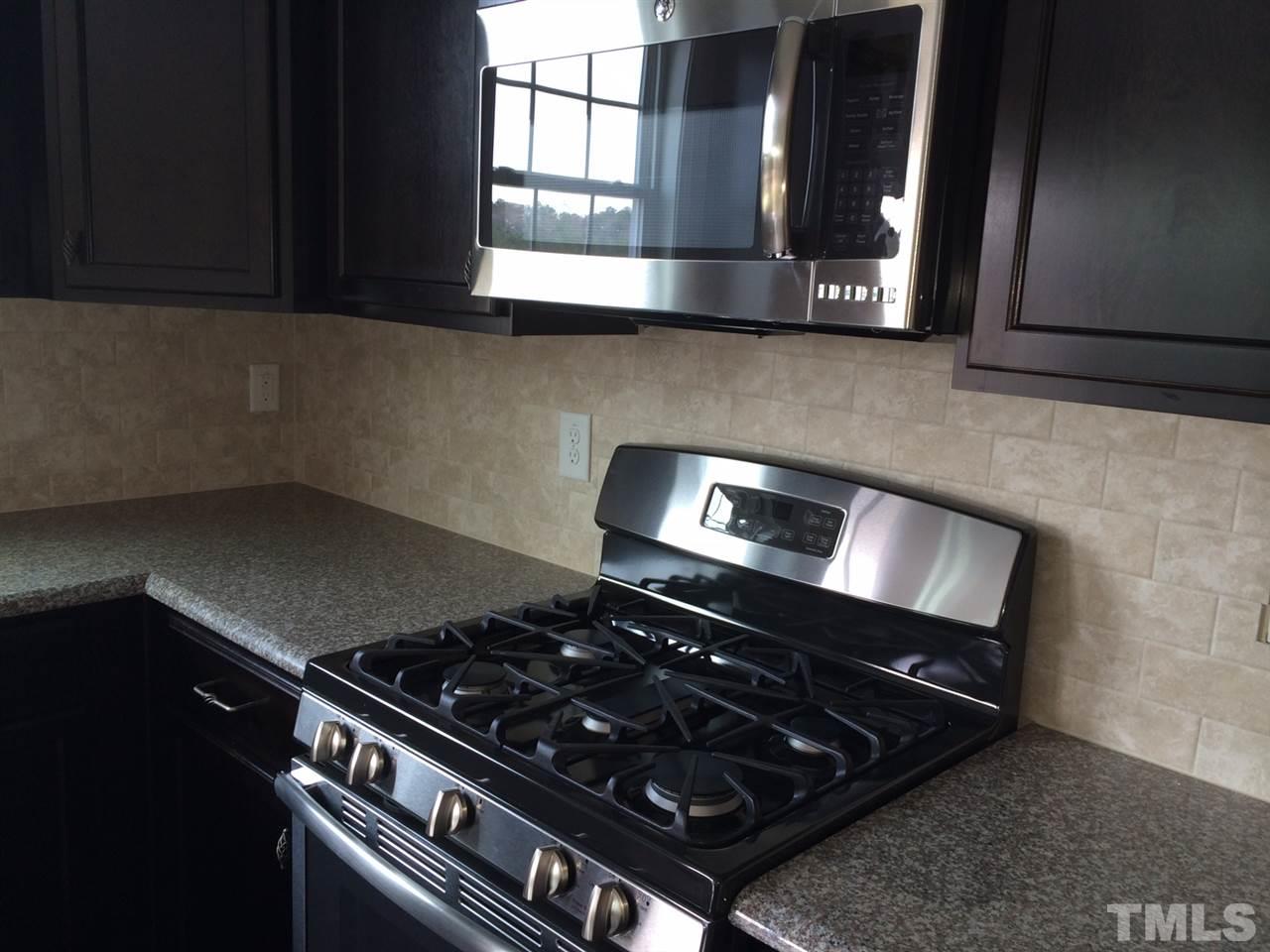 7464 Randshire Way Raleigh, NC 27616 - Photo 9 of 25 a stove top oven sitting inside of a kitchen