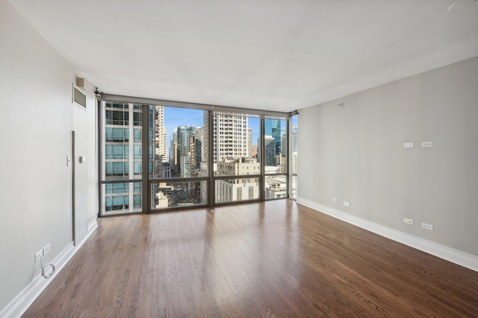 2 East Erie Street, Unit 1501 Chicago, IL 60611 - Photo 11 of 18 wooden floor in an empty room with a window