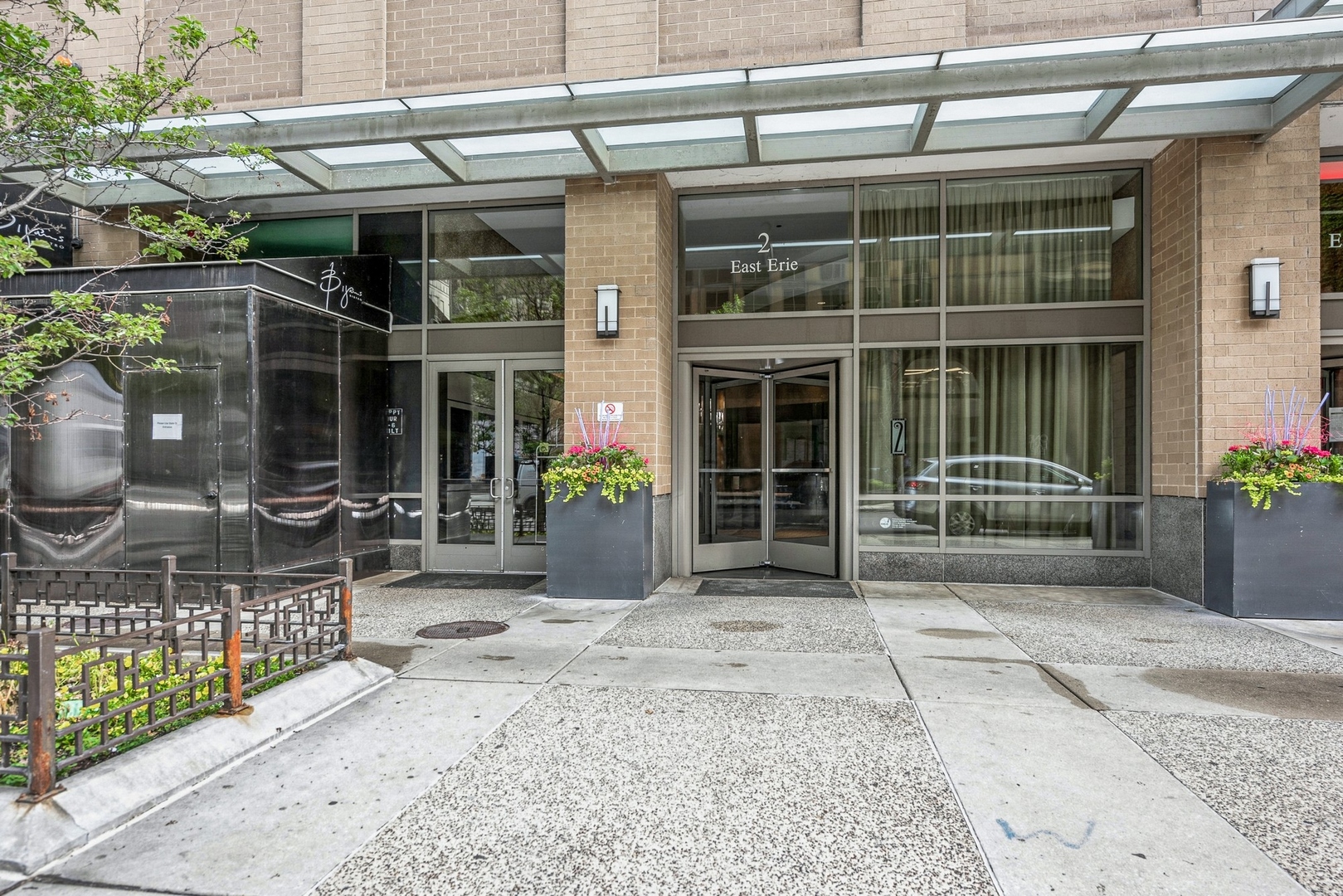 2 East Erie Street, Unit 1501 Chicago, IL 60611 - Photo 2 of 18 a front view of a house with glass windows and plants