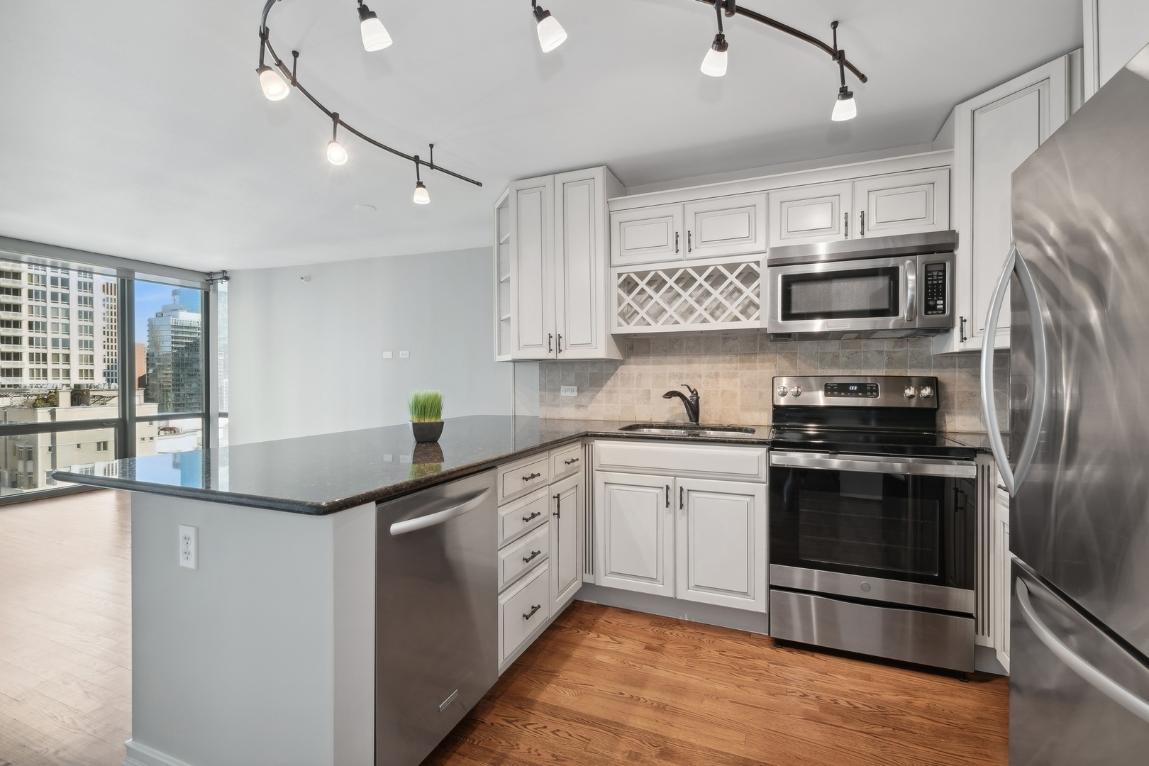 2 East Erie Street, Unit 1501 Chicago, IL 60611 - Photo 4 of 18 a kitchen with stainless steel appliances granite countertop a sink and a stove