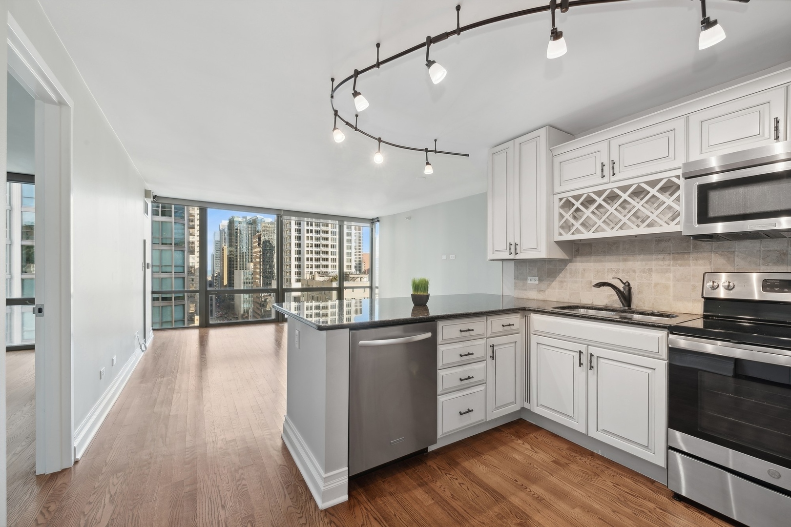 2 East Erie Street, Unit 1501 Chicago, IL 60611 - Photo 5 of 18 a kitchen with stainless steel appliances granite countertop a stove and cabinets