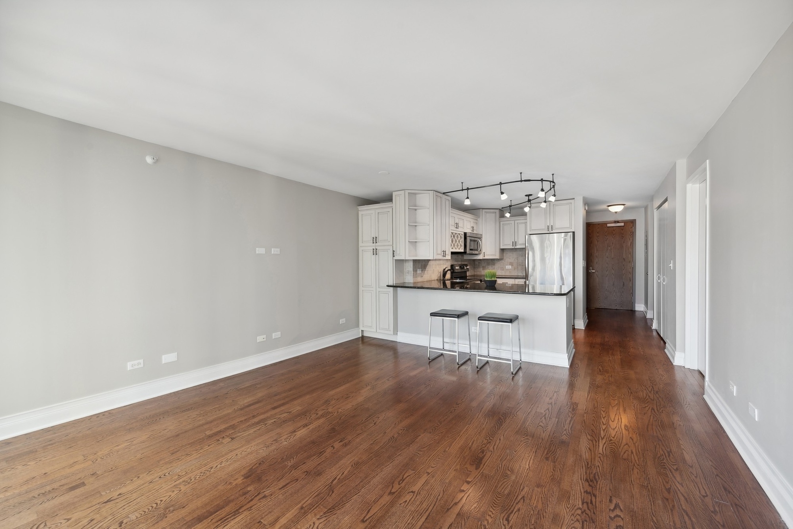 2 East Erie Street, Unit 1501 Chicago, IL 60611 - Photo 9 of 18 a kitchen with white cabinets and stainless steel appliances