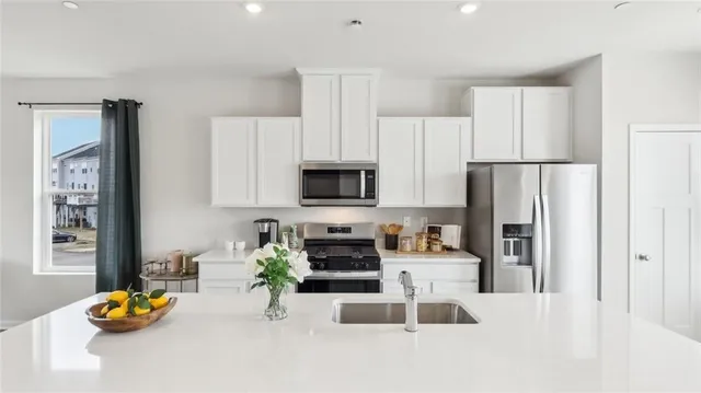 a kitchen with stainless steel appliances kitchen island granite countertop a refrigerator sink and stove