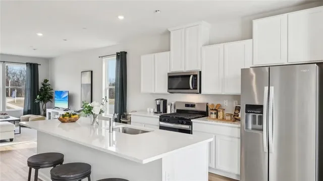 a kitchen with stainless steel appliances a refrigerator stove microwave and sink