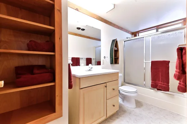a bathroom with a double vanity sink toilet and mirror