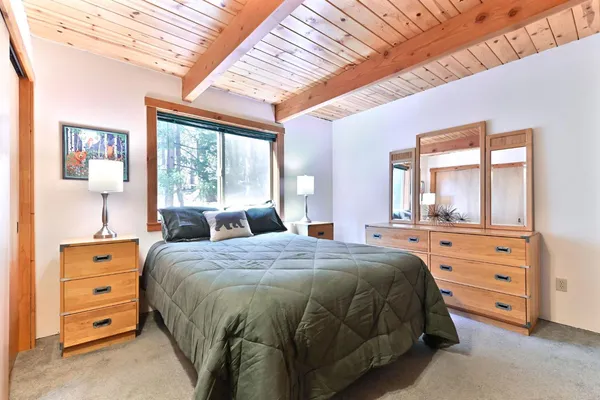 a bedroom with a bed and large windows