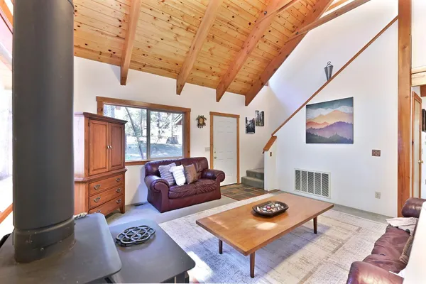 a living room with furniture a flat screen tv and a table