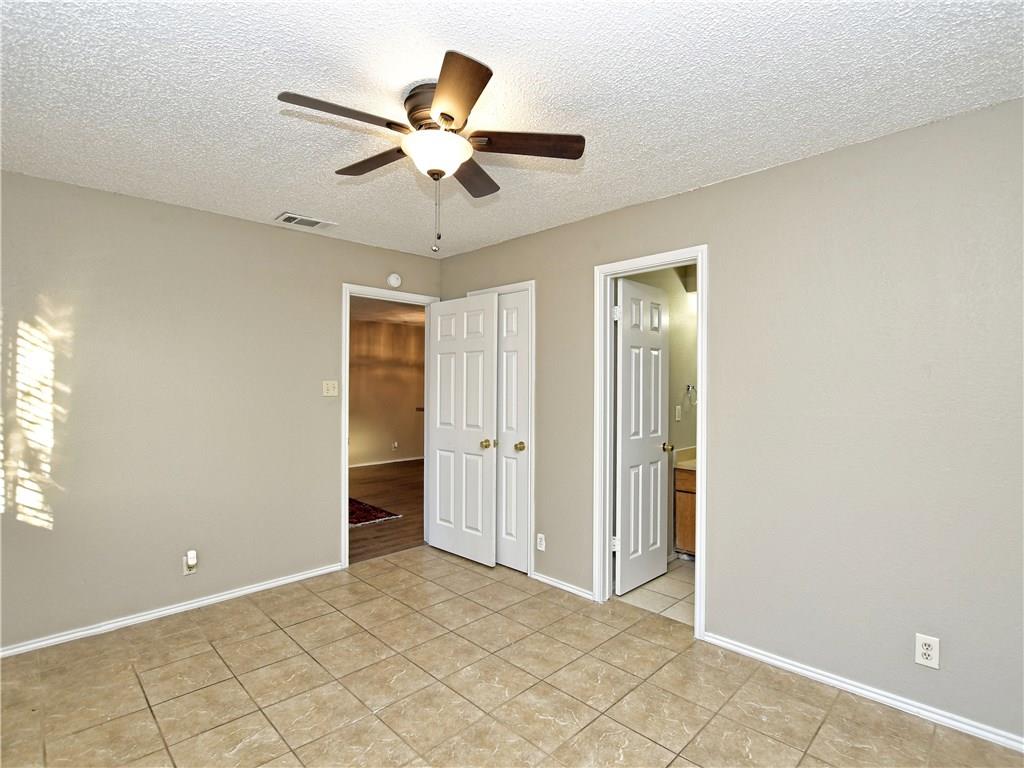 5401 Spring Meadow Road, Unit B Austin, TX 78744 - Photo 12 of 21 Functional bedroom featuring a ceiling fan and durable tile flooring, offering versatile design possibilities.