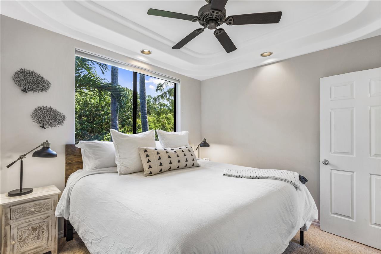 5432 Lower Honoapiilani Road, Unit B7 Lahaina, HI 96761 - Photo 15 of 27 a bedroom with a large bed and a chandelier