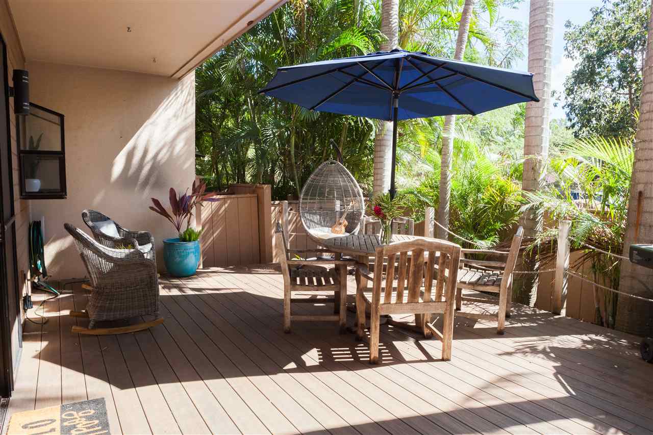 5432 Lower Honoapiilani Road, Unit B7 Lahaina, HI 96761 - Photo 20 of 27 a view of a deck with table and chairs under an umbrella with wooden floor