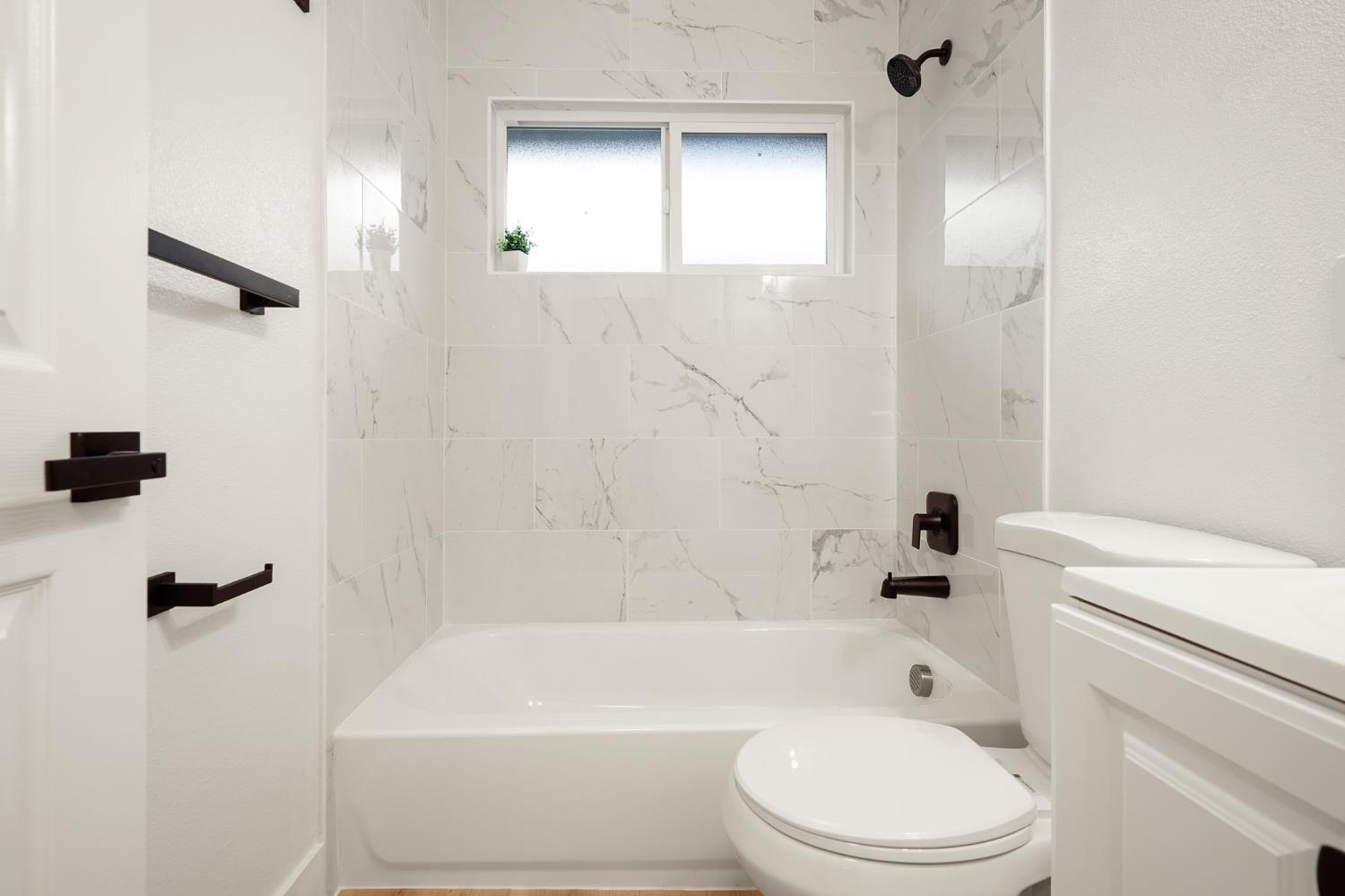 1719 West Swain Road, Unit A Stockton, CA 95207 - Photo 16 of 25 a bathroom with a toilet a sink and a bathtub