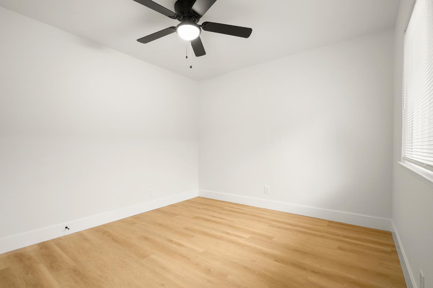 1719 West Swain Road, Unit A Stockton, CA 95207 - Photo 24 of 25 an empty room with a window and a fan