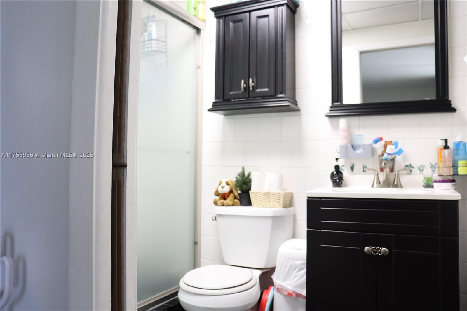8025 Southwest 107th Avenue, Unit 222 Miami, FL 33173 - Photo 11 of 27 a bathroom with a sink vanity and mirror