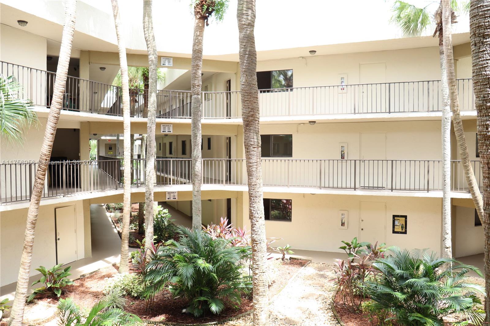 8025 Southwest 107th Avenue, Unit 222 Miami, FL 33173 - Photo 2 of 27 a front view of a building with a garden