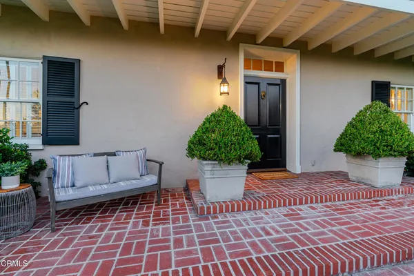 a view of a entryway door of house with potted plants