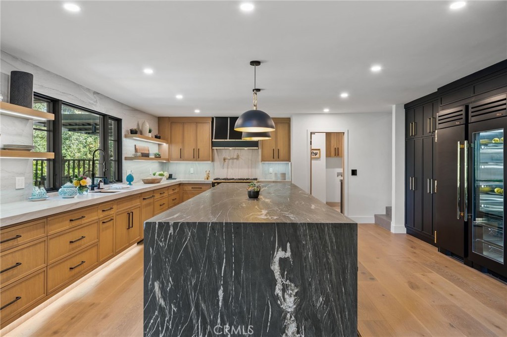 5510 Hoback Glen Road Hidden Hills, CA 91302 - Photo 23 of 60 a kitchen with kitchen island granite countertop a stove a sink dishwasher and a refrigerator with wooden floor