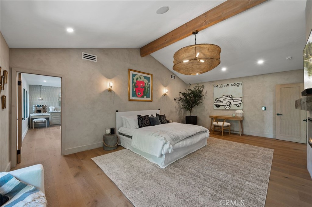 5510 Hoback Glen Road Hidden Hills, CA 91302 - Photo 32 of 60 a spacious bedroom with a large bed and a chandelier