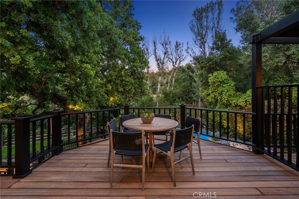 5510 Hoback Glen Road Hidden Hills, CA 91302 - Photo 48 of 60 a view of a roof deck with table and chairs with wooden floor and fence