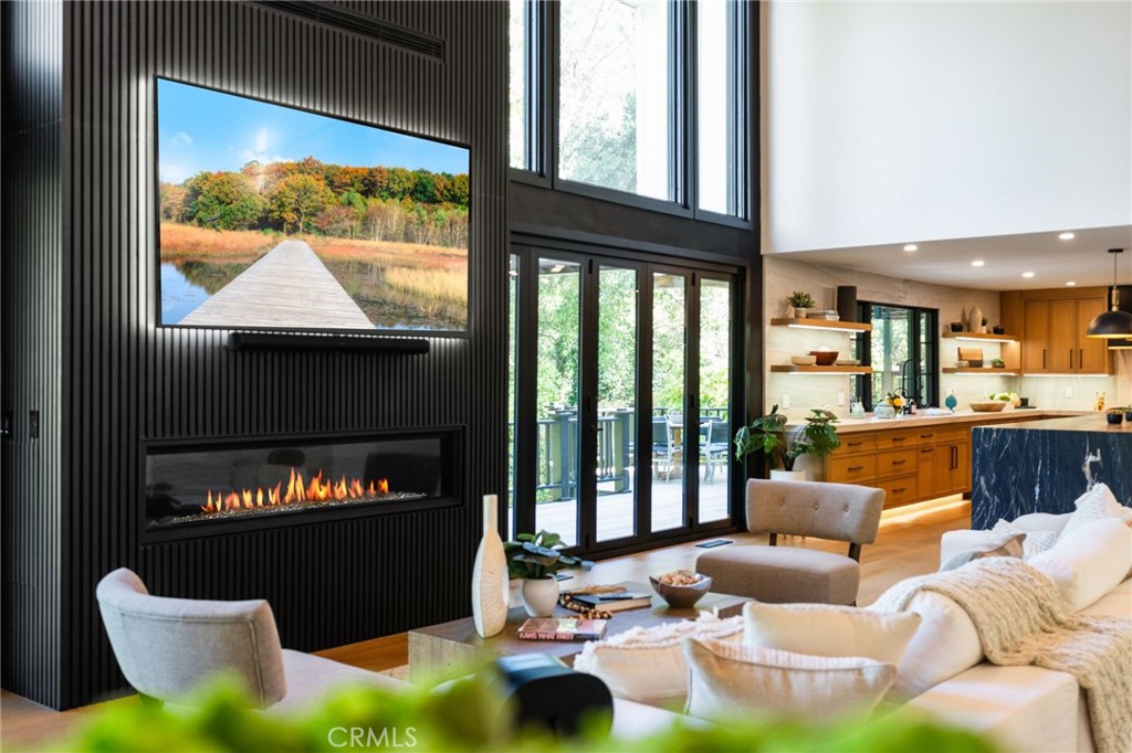 5510 Hoback Glen Road Hidden Hills, CA 91302 - Photo 8 of 60 a living room with furniture a fireplace and a floor to ceiling window