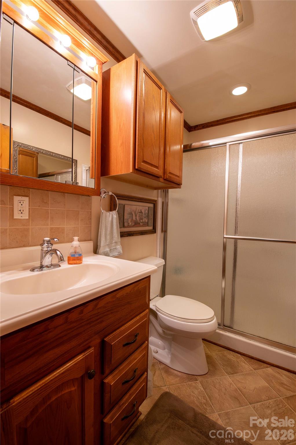 40 Double Island Road Burnsville, NC 28714 - Photo 29 of 38 a bathroom with a sink a toilet a mirror and shower