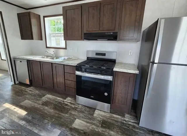 a kitchen with granite countertop a refrigerator stove and microwave
