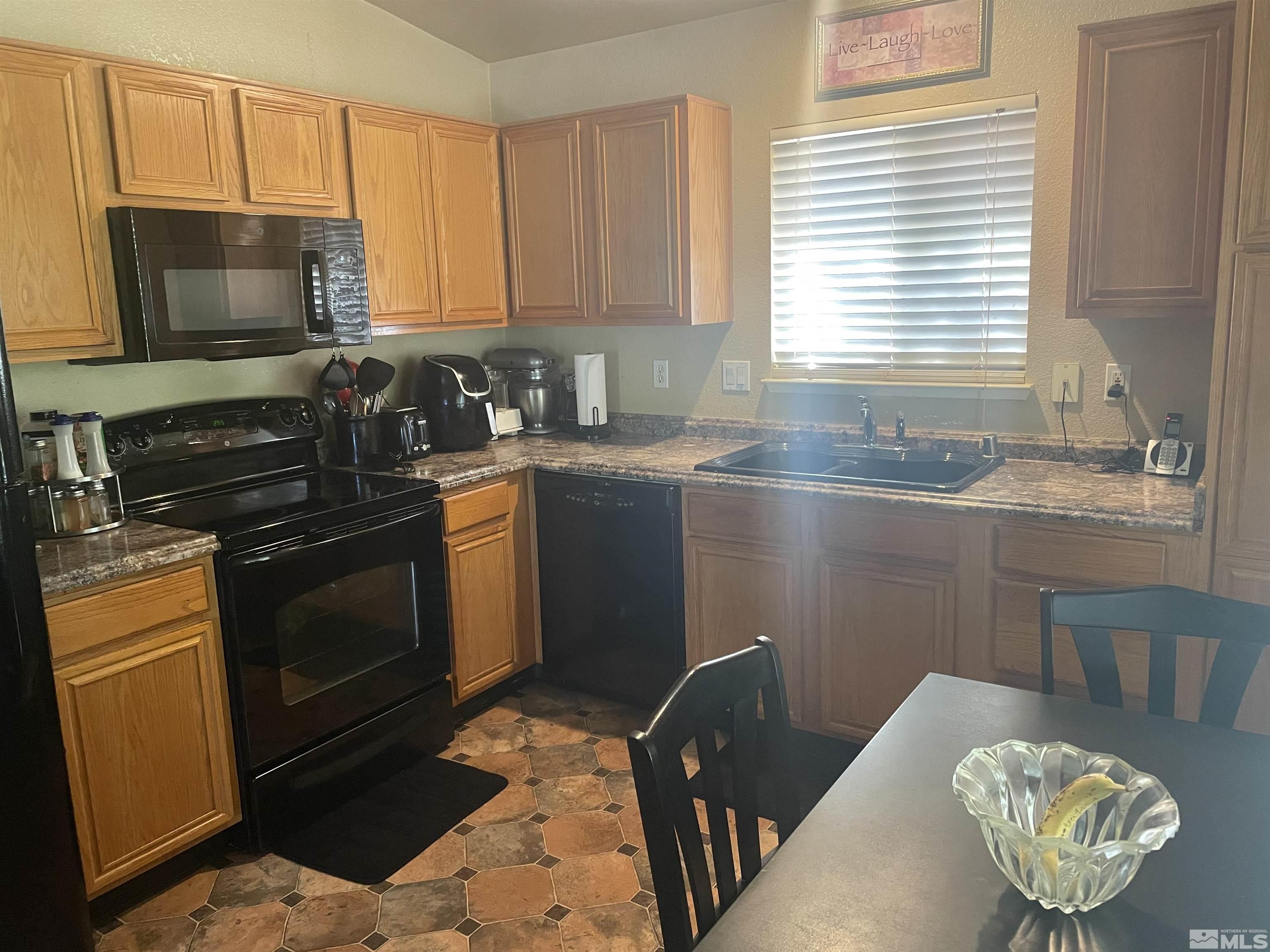 17532 Javalina Court Reno, NV 89508 - Photo 8 of 20 a kitchen with granite countertop stainless steel appliances a stove a sink a microwave a refrigerator and cabinets