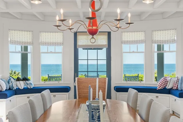 a living room with furniture chandelier and large windows