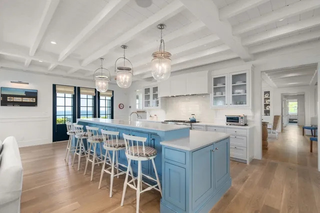 a kitchen with stainless steel appliances a dining table chairs stove and cabinets