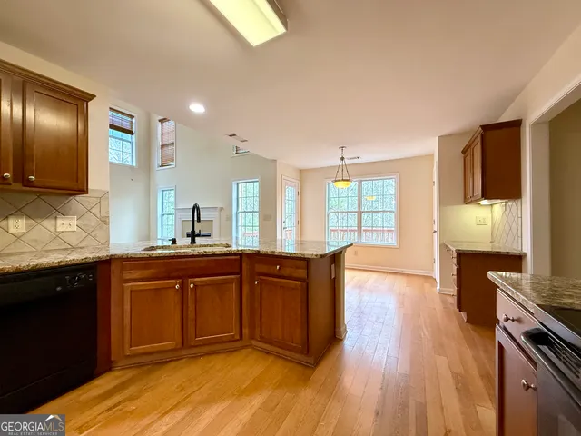 a kitchen with granite countertop wooden cabinets and a stove top oven