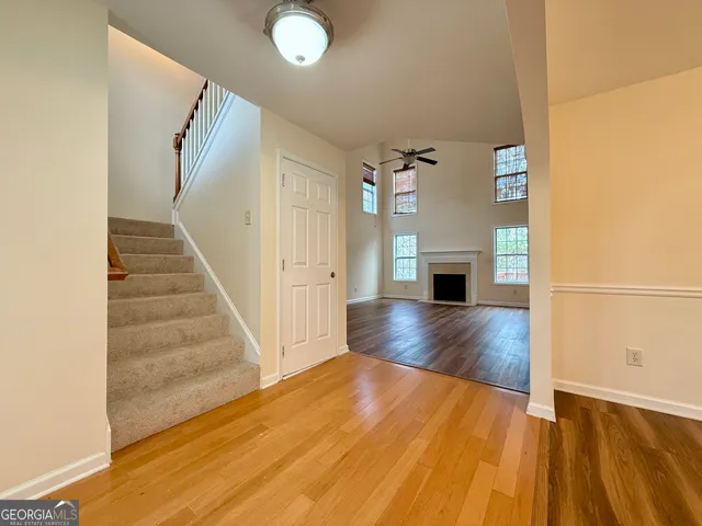 a view of a livingroom with wooden floor and staircase
