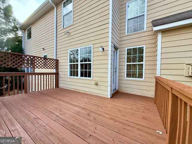 a view of an empty room with window and chandelier fan