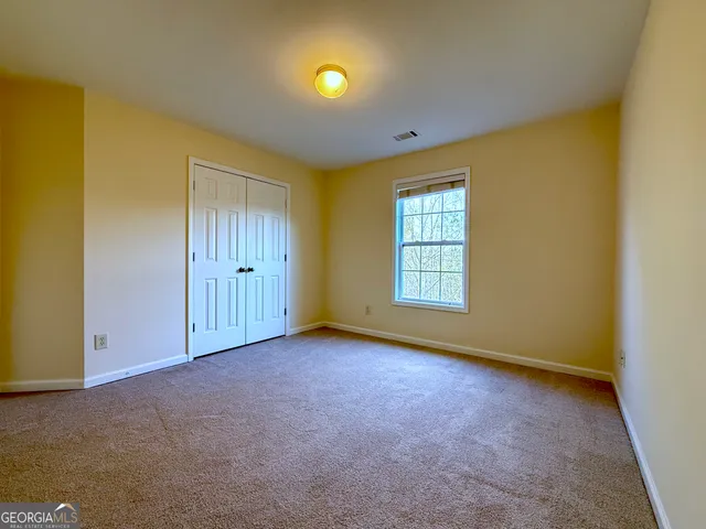 an empty room with closet and a chandelier fan