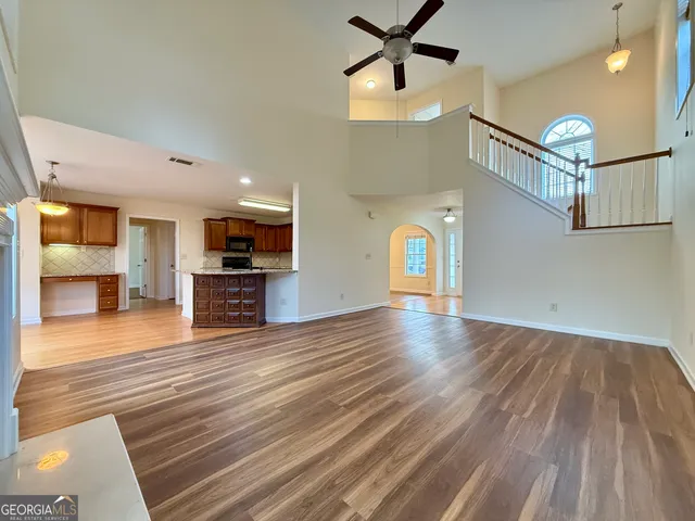 a view of a livingroom with wooden floor and a ceiling fan
