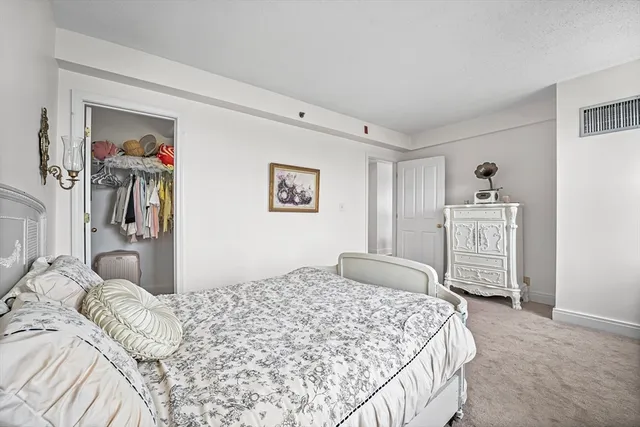 a bedroom with a large bed and a chandelier