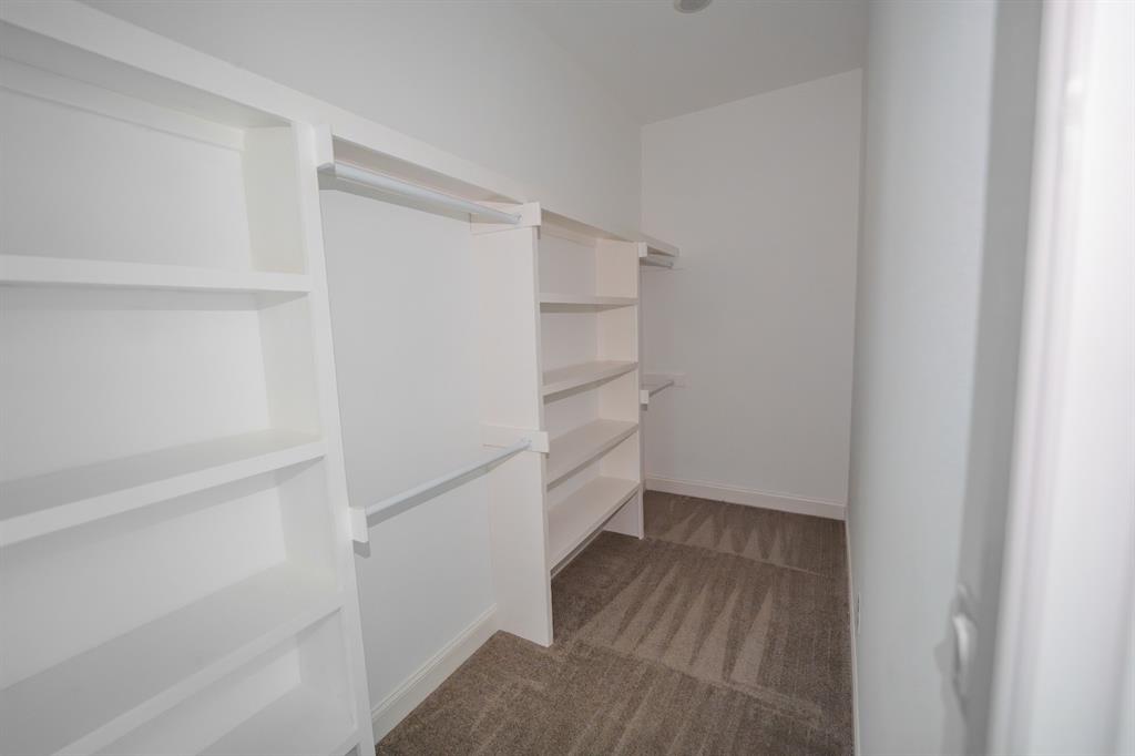 1408 Spinnaker Lane Azle, TX 76020 - Photo 7 of 8 Walk-in closet featuring built-in shelving, hanging rods, and carpet flooring