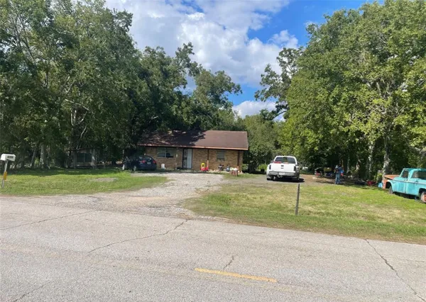 a front view of a house with a yard and trees