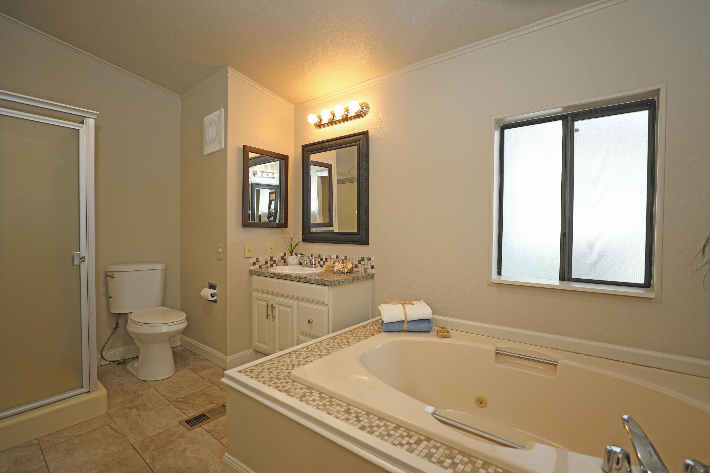 1183 Fox Den Drive Redding, CA 96003 - Photo 11 of 17 a bathroom with a granite countertop toilet sink and mirror bathtub