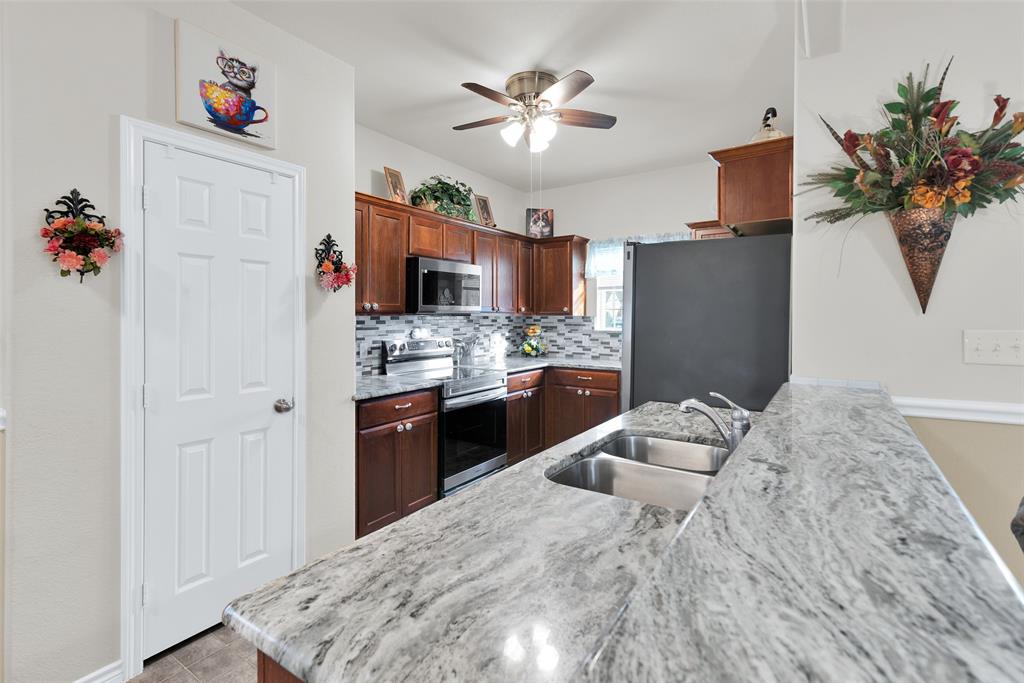 201 East Walker Street Denison, TX 75021 - Photo 7 of 19 a kitchen with stainless steel appliances kitchen island granite countertop a refrigerator and a sink